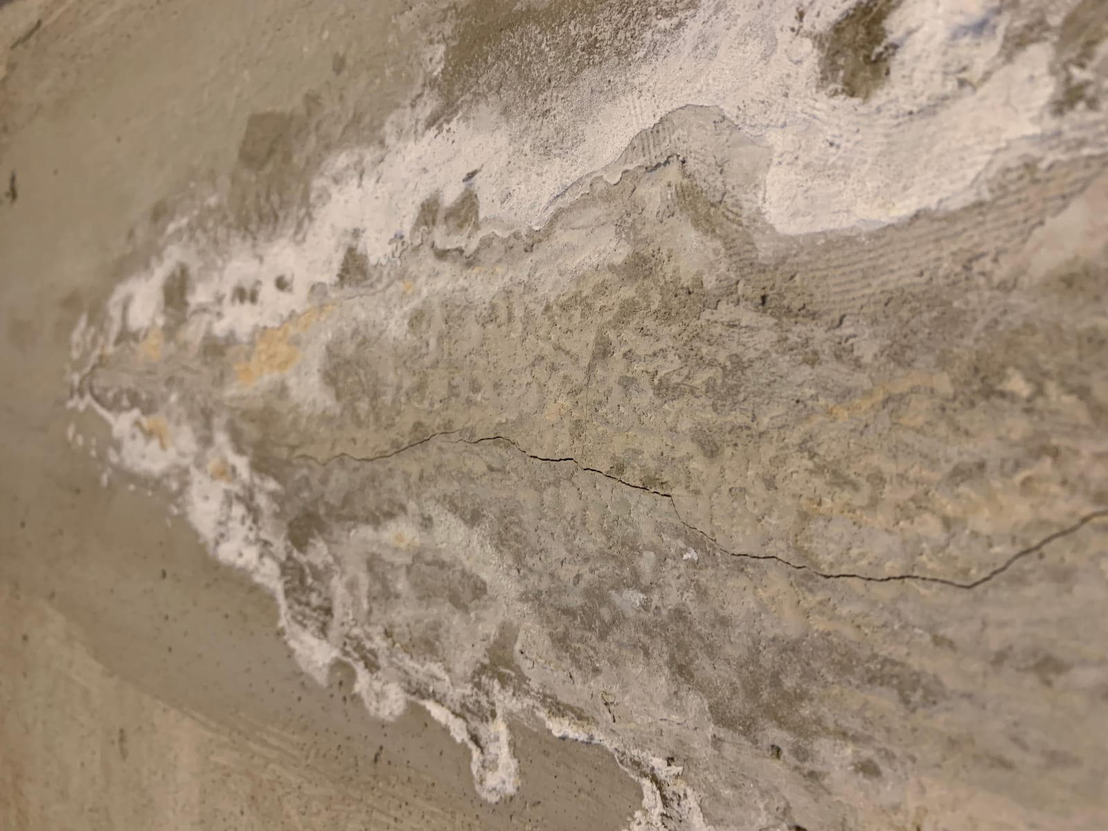Heavy white efflorescence salt deposits on a basement wall indicating active water infiltration