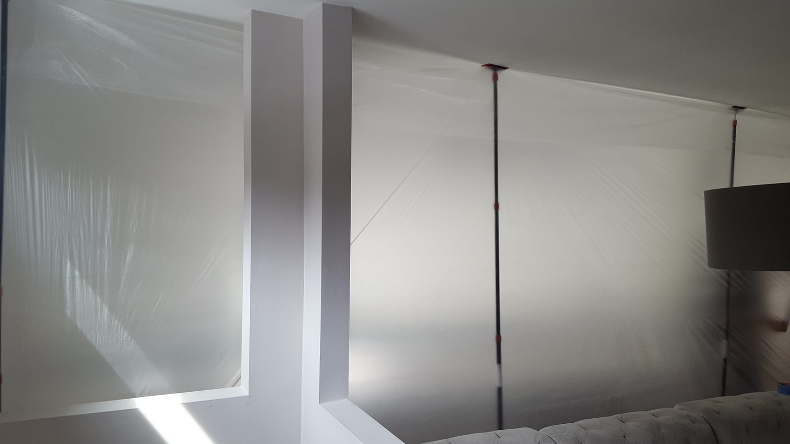 Furniture protected with plastic sheeting during mold remediation