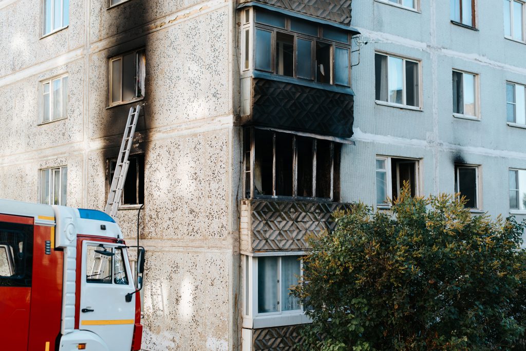 Disaster, destruction. Fire in a multi-storey apartment building. Outside black burnt balcony and windows.
