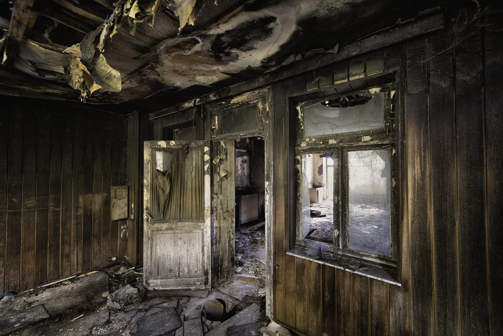 Inside shot of an abandoned destroyed building with burned walls and worn-out doors